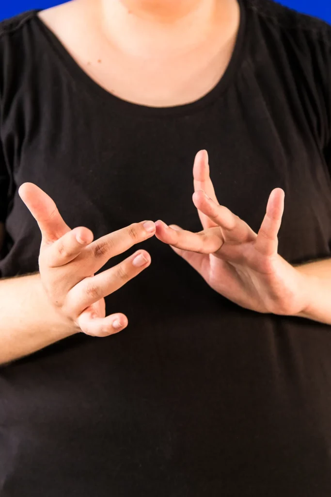 Dues mans fent el signe CONTACTE en llengua de signes catalana.